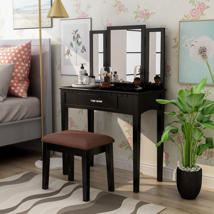 Right-angled black vanity set in a contemporary bedroom. Make-up, lotions, and pink flowers in a glass dome sit on the tabletop.
