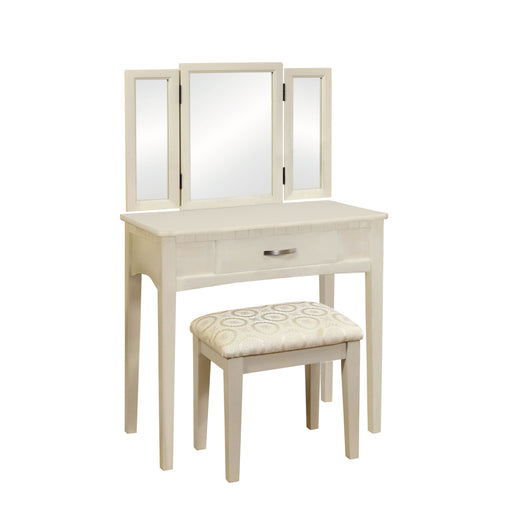 Right-angled white vanity set against a white background. A tri-fold mirror, drawer with silver bar pull, and fabric upholstered seat sit on tapered legs.