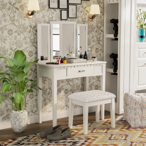 Right-angled white vanity set in a traditional bedroom. Make-up, incense, and books sit on the tabletop.