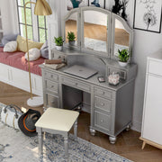 Top view of a silver vanity set in a chic teen bedroom. A laptop, iphone, and plants sit on the vanity table. To the left is a bay window seat.