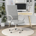 Left-angled white swivel chair in a chic home office. The high square back has channel tufting.