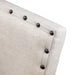 Detail shot of the nailhead trim on the beige fabric square chair back.