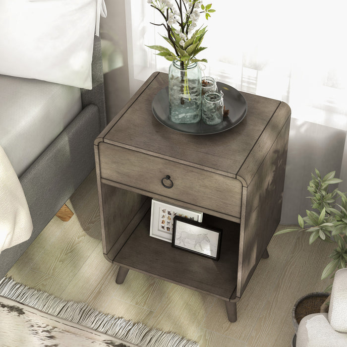 Top-view of a mid-century modern one-drawer gray wood side table in a bedroom with accessories.