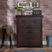 Front-facing six-drawer wood dresser on a brick wall with rustic accessories