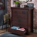 Left-angled six-drawer wood dresser with bottom drawer open on a brick wall with rustic accessories