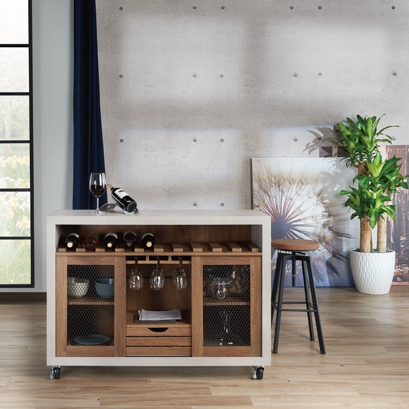 Straight-facing cement and distressed walnut wine bar cabinet against a white background. The 10 slots beneath the tabletop hold wine bottles, while the 3 stemware racks hang wine glasses. A plank-style drawer is flanked by wire-mesh cabinets. The entire buffet sits on wheels with parking brakes.