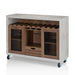 Left-angled cement and distressed walnut wine bar cabinet against a white background. The 10 slots beneath the tabletop hold wine bottles, while the 3 stemware racks hang wine glasses. A plank-style drawer is flanked by wire-mesh cabinets. The entire buffet sits on wheels with parking brakes.