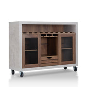 Right-angled cement and distressed walnut wine bar cabinet against a white background. The 10 slots beneath the tabletop hold wine bottles, while the 3 stemware racks hang wine glasses. A plank-style drawer is flanked by wire-mesh cabinets. The entire buffet sits on wheels with parking brakes.