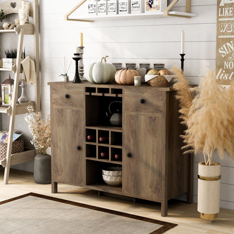 Left-angled distressed walnut wine bar cabinet against a white shiplap wall. Fall pumpkin decor adorns the tabletop. A ladder bakers rack sits on the left while a pampas plant sits on the right to create a farmhouse-style dining room.