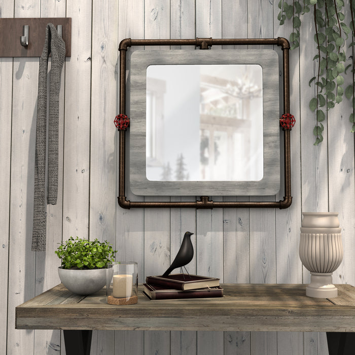 Front-facing industrial gray wood and pipe frame wall mirror with red accents over a console in a rustic living space