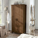 Left-angled tall, distressed walnut wardrobe cabinet with two doors in a casual bedroom