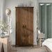 Front-facing tall, distressed walnut wardrobe cabinet with two doors in a casual bedroom