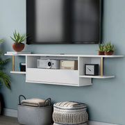 Left angled modern white floating TV console with three shelves installed on the wall of a living room with accessories