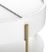 Angled close-up of gold finish iron leg and sliding top on a modern round white storage coffee table on a white background