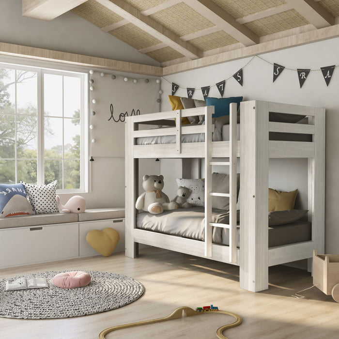 Left-facing transitional antique white twin over twin bunk bed with bedding decor in childs bedroom. Attached ladder and top bunk side rails.