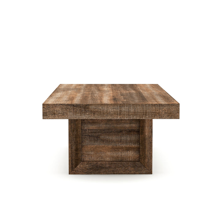 Side view of a, thick rectangular, coffee table against a white background. Unfinished solid mango wood craftsmanship is presented on sawblade-designed legs for a truly artisanal look.