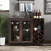 Front-facing vintage walnut wine bar cabinet in an entertainment space creates a mini home bar. A decanter and glasses sit on the tabletop. Behind the wire mesh cabinet doors are cups and plates. The wine rack holds wine bottles.