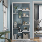 Front-facing modern white geometric bookcase with staggered shelves in a living area with accessories