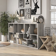 Left angled modern vintage gray oak geometric bookcase with staggered shelves laid horizontally in a living area with accessories
