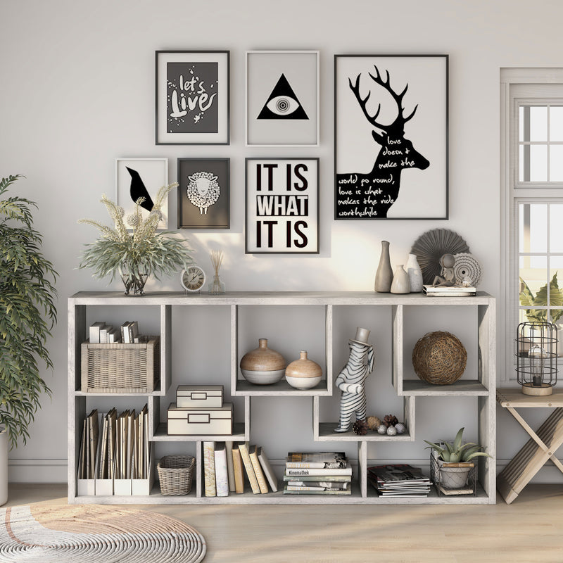 Front-facing modern vintage gray oak geometric bookcase with staggered shelves laid horizontally in a living area with accessories