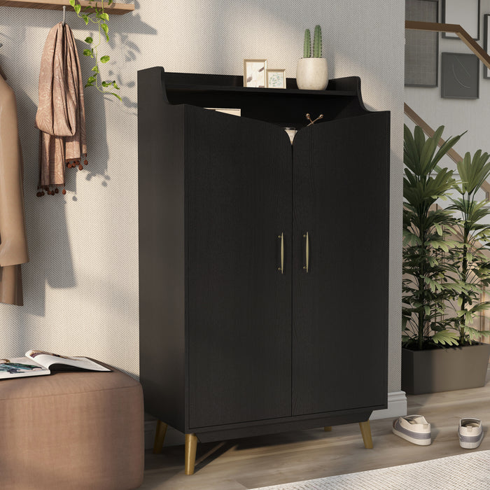 Right-angled modern black shoe cabinet with open upper shelf in foyer with accessories. Slim gold finish pulls and flared legs.