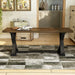 Front-facing antique oak and black trestle bench in a living area with accessories