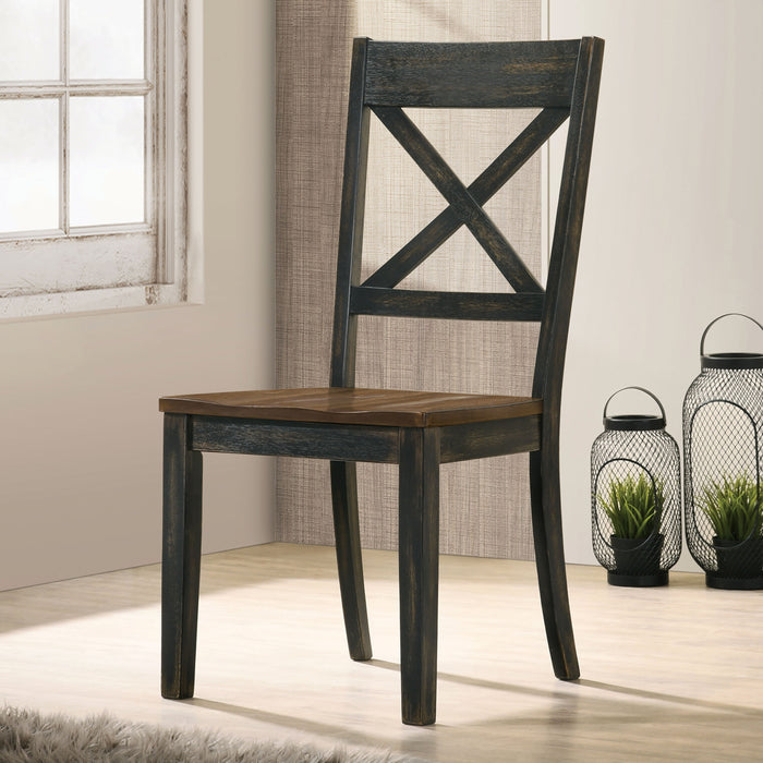 Left angled rustic antique oak and black X-back dining chair in a living space with accessories