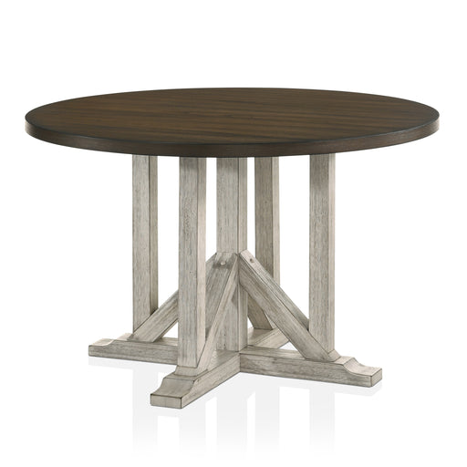 Right angled view of rustic dark oak round dining table with an antique white trestle pedestal base on a white background