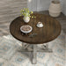 Top-down view of rustic dark oak round dining table with an antique white trestle pedestal base in a dining room with decor