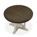 Top-down view of rustic dark oak round dining table with an antique white trestle pedestal base on a white background