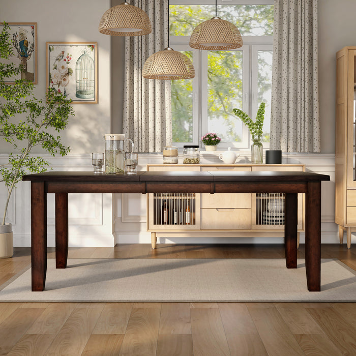 Front-facing rectangular wood dining table with an extension left and tapered post legs in a casual dining room with accessories