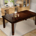 Right-angled top view rectangular wood dining table with an extension leaf and tapered post legs in a casual dining room with accessories