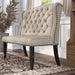 Left-angled ambrosia transitional beige nailhead trim fabric loveseat dining bench in a living room with accessories