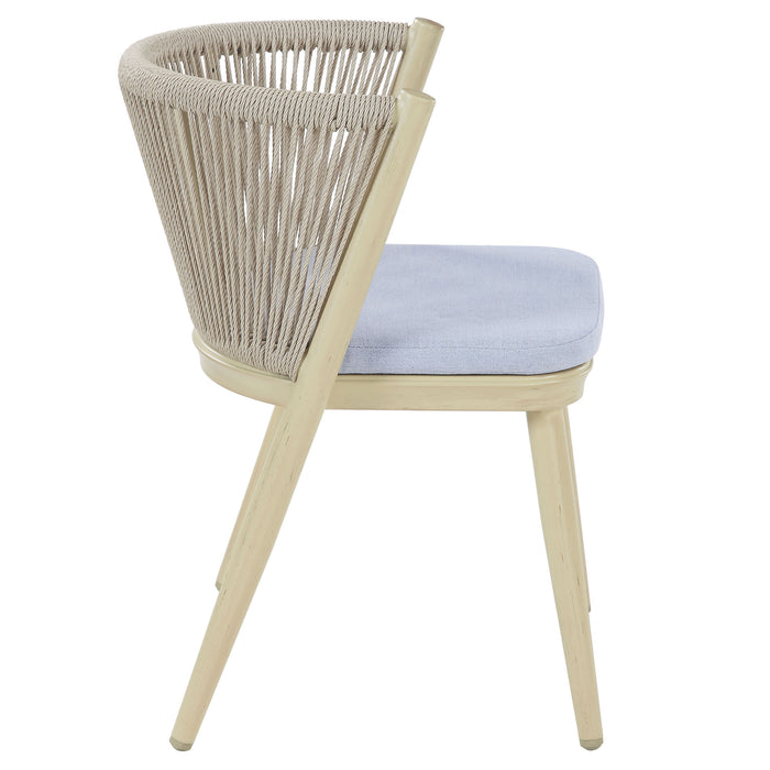Side-facing transitional aluminum patio dining chair in natural tone displaying faux wicker rope back, blue padded seat, and flared back legs on a white background.