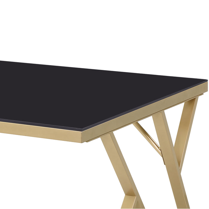 Left-angled close up modern glam dining table with a black top and gold base on a white background