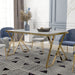 Left-angled modern glam rectangular dining table in white and gold with a geometric base in a contemporary dining room with chairs and accessories