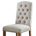 Left angled close up rustic pine and ivory button tufted dining chair upholstery and seat detail on a white background