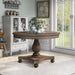Front-facing traditional round dark oak dining table in a stylish dining room with accessories