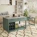 Right angled view of farmhouse green counter height table with white marble-like tabletop and extended rolling table with accessories used as kitchen island