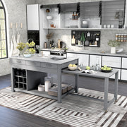 Left angled view of farmhouse light gray counter height table with white marble-like tabletop and extended rolling table with accessories used as kitchen island