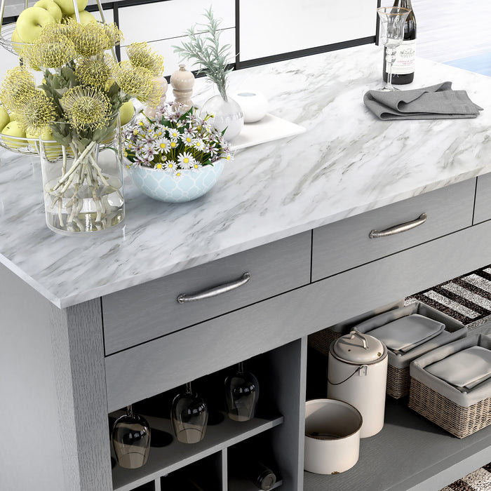 Right angled top-down view of white marble-like tabletop and drawer storage of farmhouse light gray counter height table with decor in a kitchen 