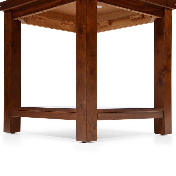 Right angled close-up view of straight block legs and open bottom shelf of transitional cherry wood end table on a white background