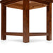 Right angled close-up view of straight block legs and open bottom shelf of transitional cherry wood end table on a white background