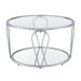 Side-facing modern round chrome steel coffee table with open teardrop shape legs, a tempered glass top, and mirror open bottom shelf on a white background.