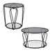 Front-facing view of modern round black nickel coffee table and end table with teardrop legs and mirrored lower shelf on a white background