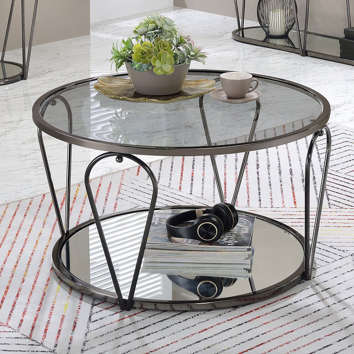 Right angled modern round black nickel coffee table with open teardrop shape steel legs, a gray tempered glass top, and mirror open bottom shelf decorated with accessories on a rug.