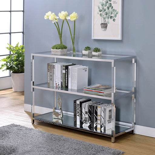 Left angled view of modern clear acrylic and chrome sofa table with glass and mirror shelves decorated with books in a living room