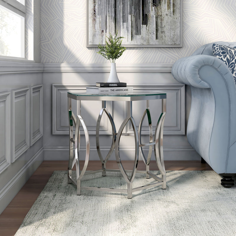 Left angled glam chrome and glass top hexagon side table in a living room with accessories