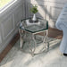 Left angled top view glam chrome and glass top hexagon side table in a living room with accessories