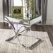 Right angled view of contemporary glam chrome finish steel and mirror end table in living room with accessories.